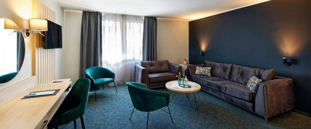 Wohnzimmer einer Doppelzimmer Suite mit Balkon mit separatem Wohnbereich.