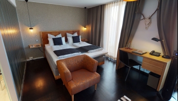 Helles, elegantes Gästezimmer (28 qm) mit großen Fenstern und Balkon mit Sitzgelegenheit, ausgestattet mit Doppelbett (2,00 x 2,10 m) oder zwei Einzelbetten (je 0,90 x 2,10 m).