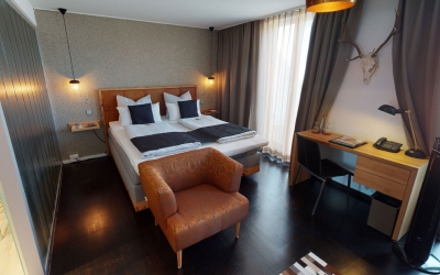 Helles, elegantes Gästezimmer (28 qm) mit großen Fenstern und Balkon mit Sitzgelegenheit, ausgestattet mit Doppelbett (2,00 x 2,10 m) oder zwei Einzelbetten (je 0,90 x 2,10 m).