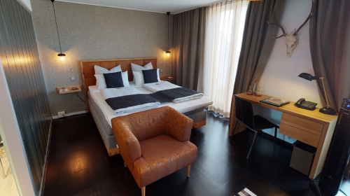 Helles, elegantes Gästezimmer (28 qm) mit großen Fenstern und Balkon mit Sitzgelegenheit, ausgestattet mit Doppelbett (2,00 x 2,10 m) oder zwei Einzelbetten (je 0,90 x 2,10 m).