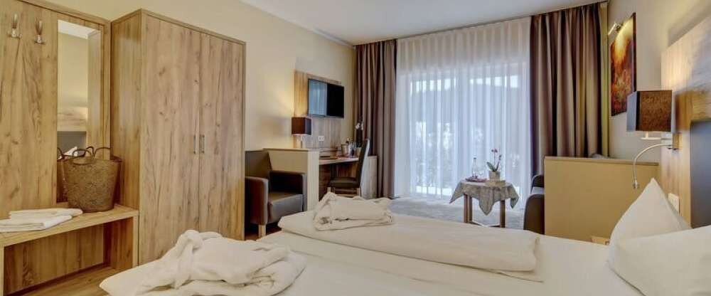 Das Doppelzimmer Wellness Premium für zwei Personen bietet einen großzügigen Wohnraum mit Couchecke und Doppelbett.