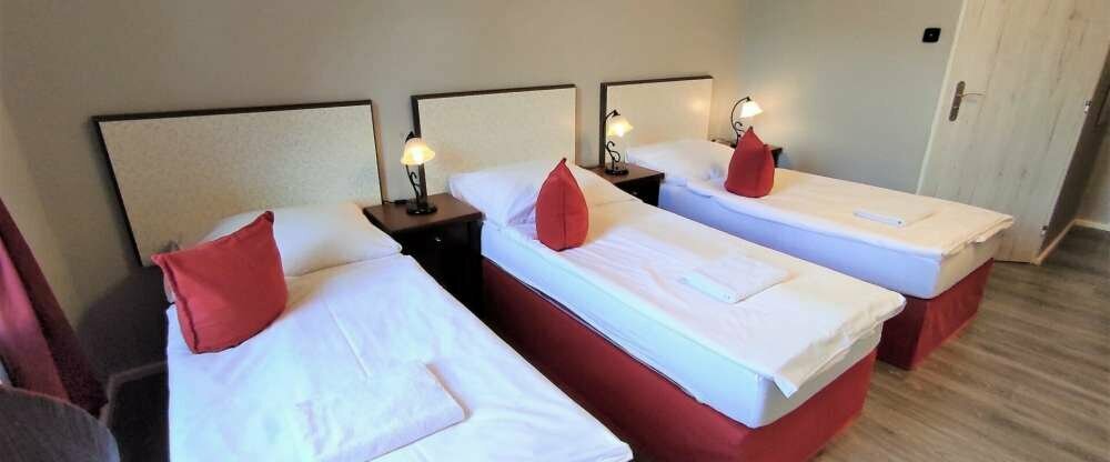 Dreibettzimmer mit eigenem Bad, ausgestattet mit drei Einzelbetten und TV. Im Zimmer gibt es ein Kaffee- und Teeset sowie einen Wasserkocher. Die Gäste werden den Blick auf den Garten auf jeden Fall zu schätzen wissen.