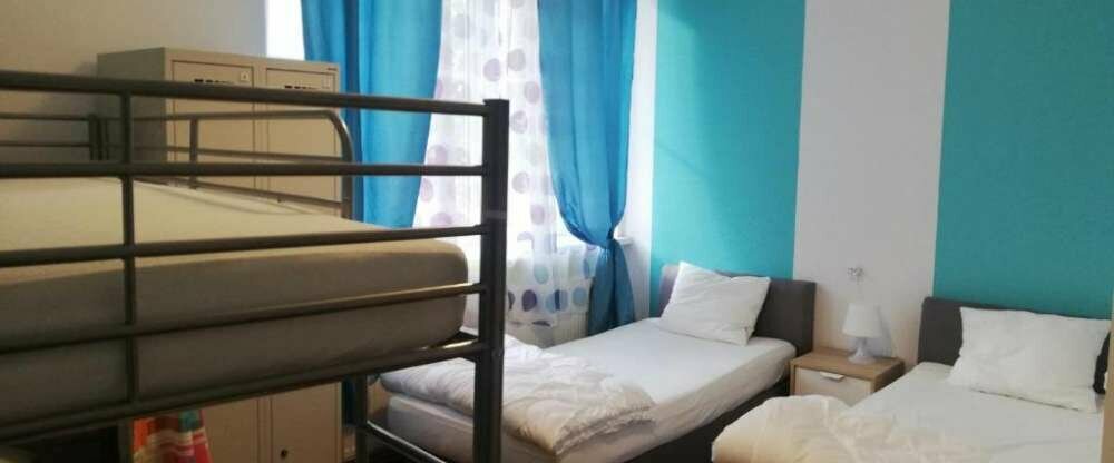 Dreibettzimmer mit zwei Einzelbetten und einem Etagenbett für 3 Personen mit Standard Ausstattung. Nutzung eines Gemeinschaftsbadezimmers. 