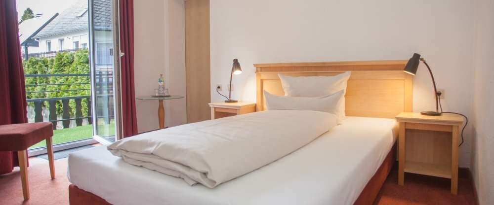 Die Einzelzimmer sind mit einem Kleiderschrank und separatem Badezimmer / Dusche, Haartrockner, einem Schreibtisch, modernem Flat TV und gratis WLAN ausgestattet.