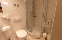 Das freundlich und funktional eingerichtete Einzelzimmer mit ca. 15m² bietet eine angenehme Wohlfühlatmosphäre für Alleinreisende. Das Einzelbett (90 × 200 cm) ist in eine warme Holzverkleidung eingebettet und mit einer Leselampe sowie Steckdosen direkt a