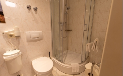 Das freundlich und funktional eingerichtete Einzelzimmer mit ca. 15m² bietet eine angenehme Wohlfühlatmosphäre für Alleinreisende. Das Einzelbett (90 × 200 cm) ist in eine warme Holzverkleidung eingebettet und mit einer Leselampe sowie Steckdosen direkt a