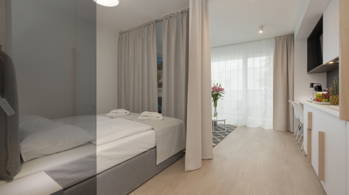 Komfortables Einzimmer-Apartment mit einer Fläche von 26 m², bestehend aus einem Wohnzimmer mit Kochnische, Bad und einem separaten Schlafbereich mit Doppelbett. Wir schätzen die Privatsphäre unserer Gäste, deshalb ist der Aufenthaltsbereich vom Schlafber