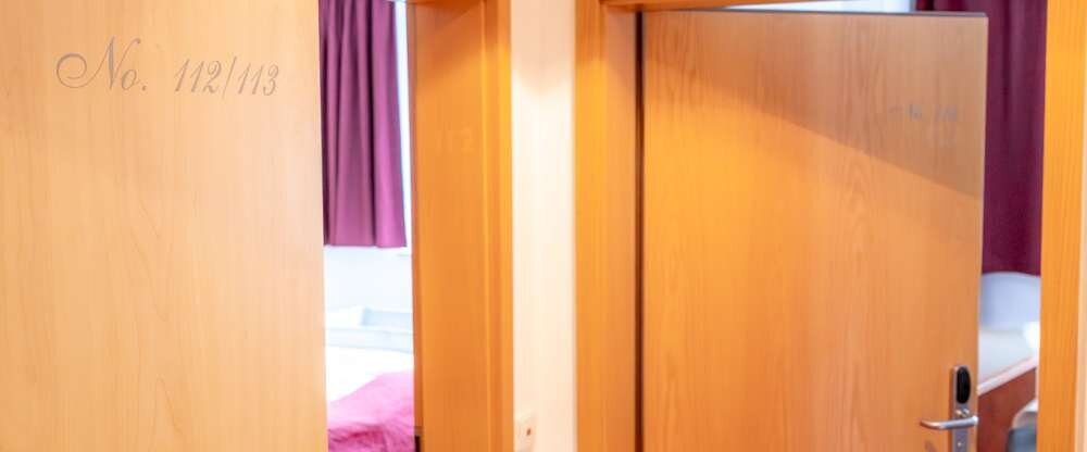 Familienzimmer mit Verbindungstür: Ideal für Familien – zwei gemütliche Doppelbetten, zwei separate Bäder, TV in jedem Raum und elektrische Rollläden für extra Komfort und Verdunkelung. Das 5. Bett kann ein Baby-Reisebett oder ein Schlafsessel sein. Id