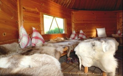 Ruhealp mit Rentierfellen und Blick zur offenen Feuerstelle