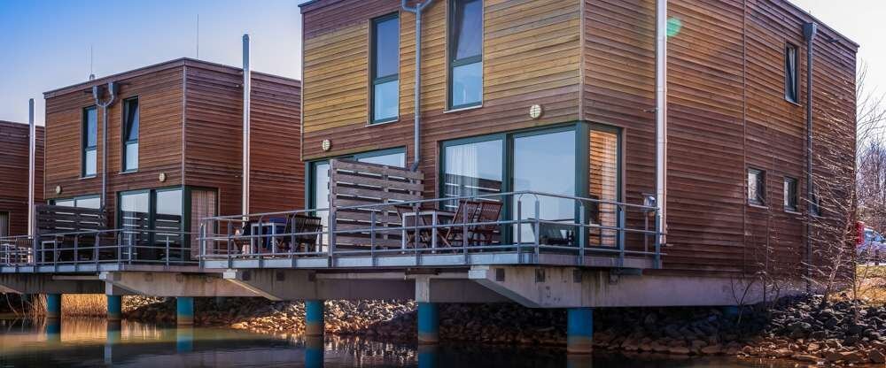 Doppelhaushälfte im Maisonette-Stil 1 Wohn-/ Essbereich im Erdgeschoß mit Einbauküche, Esstisch,Couch (mit Schlaffunktion für die 5. Person - gegen Aufpreis), Flat-TV, 1 Kaminofen 1 Gäste-WC im Erdgeschoß Außenterrasse über dem Wasser mit Sitzgruppe &a