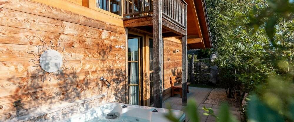 Das Heimat-Chalet hat eine Wohnfläche von 120m² und verfügt über einen Wohnraum mit kleiner Küche, ein Schlafzimmer im Parterre, ein großes Badezimmer mit DU/WC, ein separates DU/WC und eine gemütliche Galerie im Obergeschoß mit Balkon, mit Doppel-Wasserb