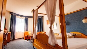 Das Himmelbett-Zimmer entspricht in Stil und Atmosphäre einem Schwarzwald-Zimmer, setzt jedoch mit seinem romantischen Himmelbett einen besonderen Akzent. Mit viel Liebe zum Detail gestaltet, verbindet es traditionellen Schwarzwald-Charme mit modernem Kom