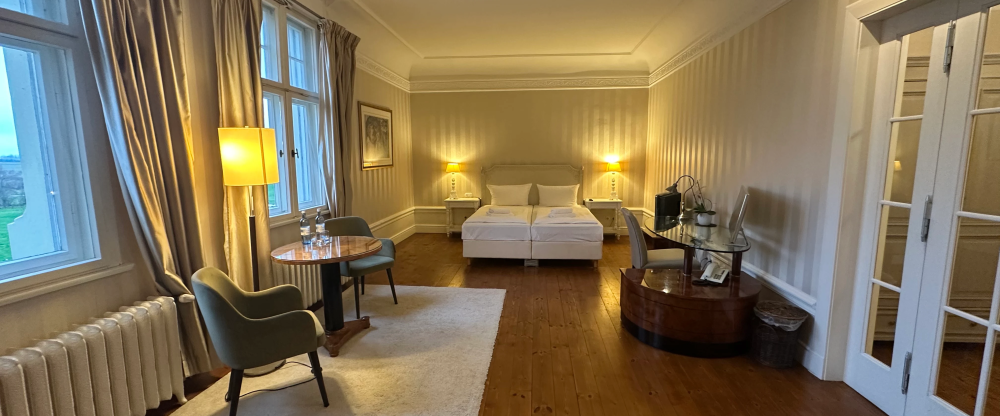 Die großzügige Junior Suite im historischen Schlossgebäude von Schloss Krugsdorf verbindet eleganten Komfort mit einem beeindruckenden Ausblick auf den malerischen Schlosspark und den angrenzenden Golfplatz. Die stilvoll eingerichteten Räume bieten viel P