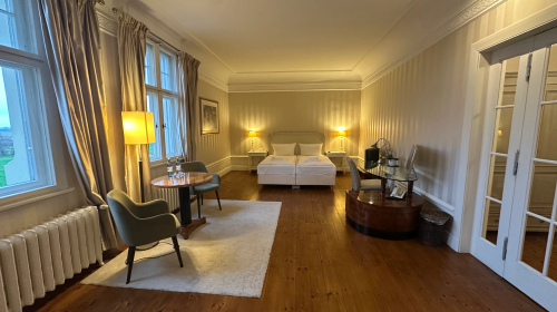 Die großzügige Junior Suite im historischen Schlossgebäude von Schloss Krugsdorf verbindet eleganten Komfort mit einem beeindruckenden Ausblick auf den malerischen Schlosspark und den angrenzenden Golfplatz. Die stilvoll eingerichteten Räume bieten viel P