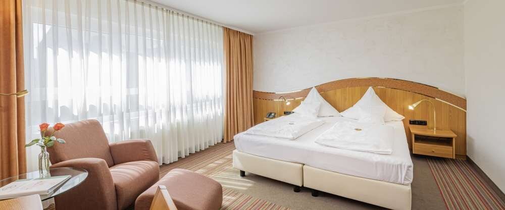 32 m², Doppelbett mit zwei separaten Matratzen (210x100), Schreibtisch mit Stuhl, Glastisch mit 2 Sesseln, kostenloses WLAN, Minibar, Safe, Kofferbock, großzügiger Kleiderschrank, 80cm Flat-TV mit über 70 mehrsprachigen Sendern, zur Bahnseite gelegen. Al