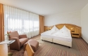 32 m², Doppelbett mit zwei separaten Matratzen (210x100), Schreibtisch mit Stuhl, Glastisch mit 2 Sesseln, kostenloses WLAN, Minibar, Safe, Kofferbock, großzügiger Kleiderschrank, 80cm Flat-TV mit über 70 mehrsprachigen Sendern, zur Bahnseite gelegen. Al