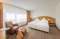 32 m², Doppelbett mit zwei separaten Matratzen (210x100), Schreibtisch mit Stuhl, Glastisch mit 2 Sesseln, kostenloses WLAN, Minibar, Safe, Kofferbock, großzügiger Kleiderschrank, 80cm Flat-TV mit über 70 mehrsprachigen Sendern, zur ruhigeren Kirchseite g