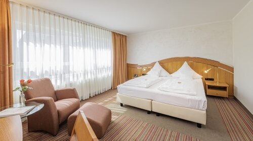 32 m², Doppelbett mit zwei separaten Matratzen (210x100), Schreibtisch mit Stuhl, Glastisch mit 2 Sesseln, kostenloses WLAN, Minibar, Safe, Kofferbock, großzügiger Kleiderschrank, 80cm Flat-TV mit über 70 mehrsprachigen Sendern, zur ruhigeren Kirchseite g