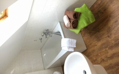 Die Badezimmer im waldhotel AUSZEIT sind mit  Wanne/Sitzdusche oder Dusche ausgestattet. Beispiel hier: Badezimmer mit Wanne/Sitzdusche