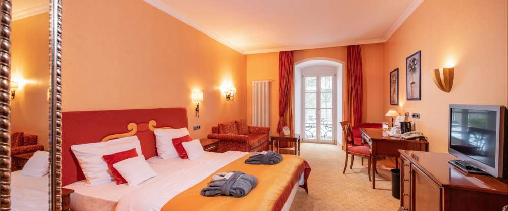 Die großzügigen Komfort-Doppelzimmer in der Schlosspark Villa sind ausgestattet mit exklusiven Möbeln und Stoffen und vermitteln Luxus, Eleganz und Schönheit. Fühlen Sie sich hier wie Zuhause. Mediterrane, warme Farben und dunkle Kirschbaummöbel geben dem