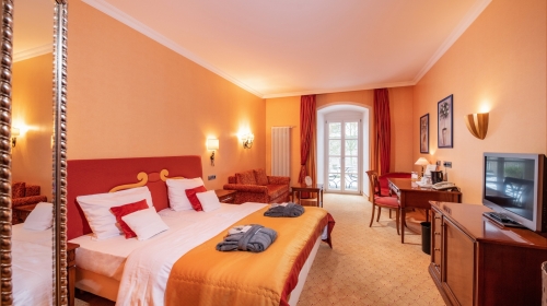 Die großzügigen Komfort-Doppelzimmer in der Schlosspark Villa sind ausgestattet mit exklusiven Möbeln und Stoffen und vermitteln Luxus, Eleganz und Schönheit. Fühlen Sie sich hier wie Zuhause. Mediterrane, warme Farben und dunkle Kirschbaummöbel geben dem