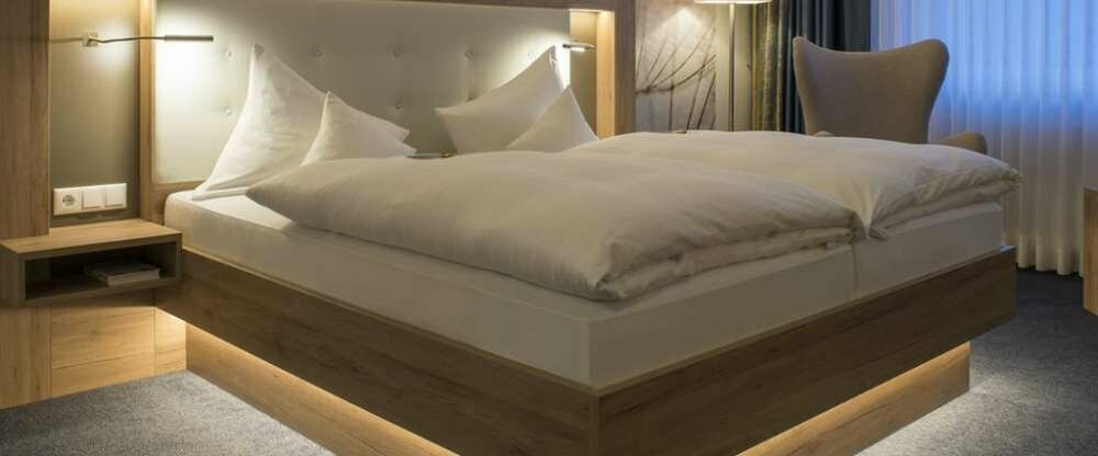 Geräumiges Zimmer mit Schreibtisch, Stühlen, Sitzgelegenheit, LCD TV und Doppelbett. Das Badezimmer ist mit einem großen Spiegel, Dusche und Haartrockner ausgestattet.