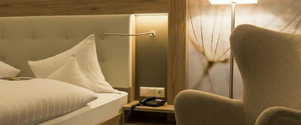 Geräumiges Zimmer mit Schreibtisch, Stühlen, Sitzgelegenheit, LCD TV und Doppelbett. Das Badezimmer ist mit einem großen Spiegel, Dusche und Haartrockner ausgestattet.