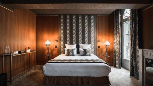 Hinter einer majestätischen Eichentür offenbart das Schlafzimmer im Pariser Stil eine raffinierte Atmosphäre, durchdrungen von der Eleganz der Belle Époque. Im Badezimmer filtert eine Buntglasdecke im Jugendstil das Licht auf anmutige Weise.