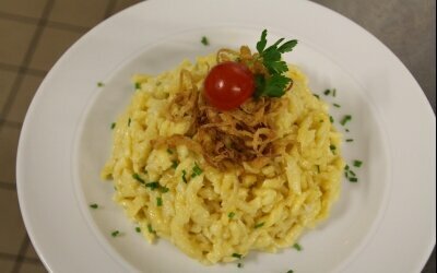 sind unsere Käsespätzle. Hausgemachte Spätzle mit Käse aus der Region und geschmelzten Zwiebeln