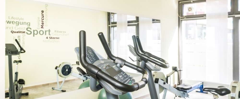 Fitnessbereich mit Ergometern, Rudermaschinen und Hanteln