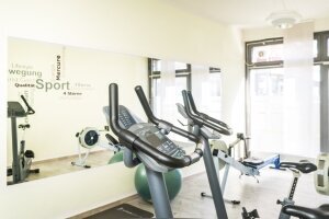 Fitnessbereich mit Ergometern, Rudermaschinen und Hanteln