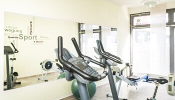 Fitnessbereich mit Ergometern, Rudermaschinen und Hanteln