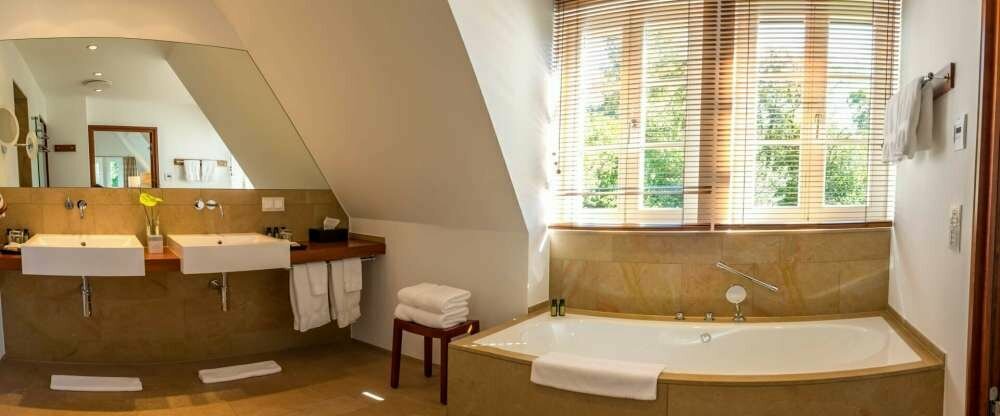 90qm, offener Kamin, Tageslichtbad mit Dusche und Wanne, komfortabele Betten (200x200), separate Toilette, klimatisiert, im Wellnessbereich, Blick in die Natur, Flat-TV, Fön, Bademantel, Minibar, Nespresso Kaffeemaschine, Safe, freies Wlan, Wellnesstasche