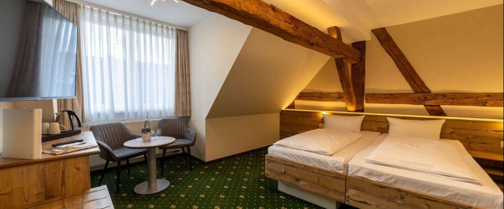 Unsere Premiumzimmer verbinden modernen Komfort mit charmantem Landhausflair. Auf ca. 22m² bis 25m² erwartet Sie ein liebevoll gestalteter Rückzugsort für bis zu 2 Personen, geprägt von sichtbaren Holzbalken, warmen Naturtönen und einer behaglichen Aussta