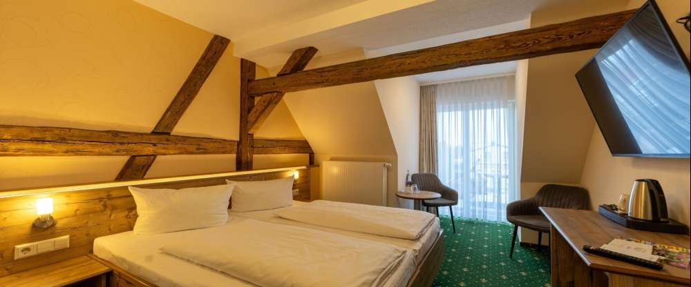 Unser Premiumzimmer mit Balkon verbindet modernen Komfort mit gemütlichem Charme. Auf ca. 17m² bis 25m² erwartet Sie ein liebevoll gestalteter Rückzugsort für bis zu zwei Personen, der durch warme Naturtöne, hochwertige Materialien und sichtbare Holzbalke