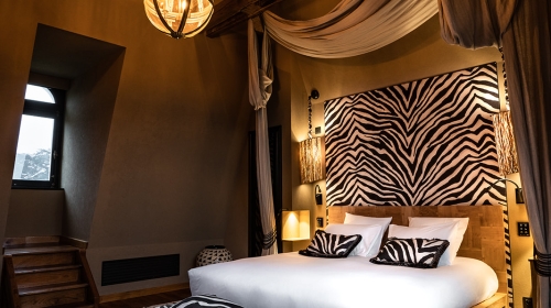 Erleben Sie das Abenteuer der Rückkehr von einer Reise neu, wo jede Erinnerung eine Geschichte ist, die erzählt werden will. Dieses Zimmer hüllt Sie in eine Mischung aus Nostalgie und Entdeckergeist ein, mit einer wilden und einladenden Einrichtung.