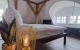 Hier erwartet Sie ein unvergleichliches Erlebnis: Ein exklusives Kingsize-Bett schwingt sanft am Gebälk unter dem Dach des historischen Schlosses und bietet eine romantische Atmosphäre, die Sie nie vergessen werden.

Romantik & Luxus: Genießen Sie d