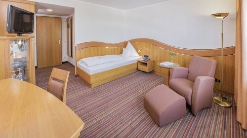 24 m², Einzelbett (210x100), Schreibtisch mit Stuhl, Glastisch mit Sessel, kostenloses WLAN, Minibar, Safe, Kofferbock, großzügiger Kleiderschrank, 80cm Flat-TV mit über 70 mehrsprachigen Sendern, zur Bahnhofseite gelegen.
Alle Zimmer mit Dusche und/ ode