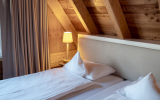 Das luxuriöse Chalet bietet auf zwei Etagen rund 50 m². Das vorherrschende Element ist Holz. Dielenfußboden, Wände, der beeindruckende offene Dachstuhl mit massiven Balken, die Treppe zur oberen Etage sind aus Kiefernholz, genau wie der große Balkon mit g