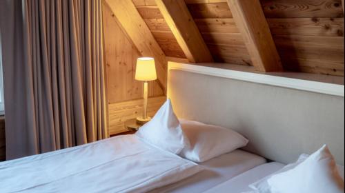 Das luxuriöse Chalet bietet auf zwei Etagen rund 50 m². Das vorherrschende Element ist Holz. Dielenfußboden, Wände, der beeindruckende offene Dachstuhl mit massiven Balken, die Treppe zur oberen Etage sind aus Kiefernholz, genau wie der große Balkon mit g