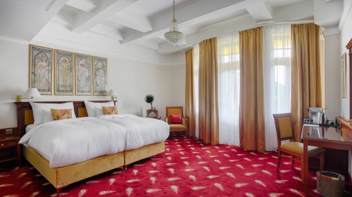 Exklusive Suite mit 53 m2 mit Werken des Künstlers Alfons Mucha, in der Kunst und Eleganz auf den Komfort der modernen Zeit treffen. Die Suite bietet einen eleganten Wohnbereich mit einem Schlafsofa, ein geräumiges Schlafzimmer, das mit Reproduktionen von