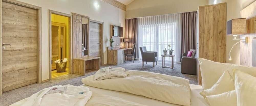 Die Wellness Suite verfügt über einen großzügigen Wohnraum mit Couchecke und Doppelbett. Zudem verfügt dieses Zimmer über eine eigene Infrarotrauna.