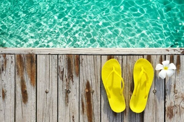 Yellow sandals by a swimming pool