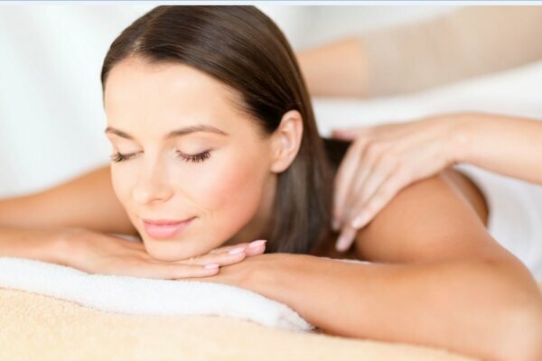 health, beauty, resort and relaxation concept - beautiful woman with closed eyes in spa salon getting massage